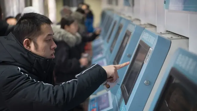 1月4日，山西太原火车站，使用网络购票的旅客在自动取票机上领取火车票。网络购票已成为旅客主要选择，在太原站，自动取票机的票据需求是人工售票窗口的3倍。