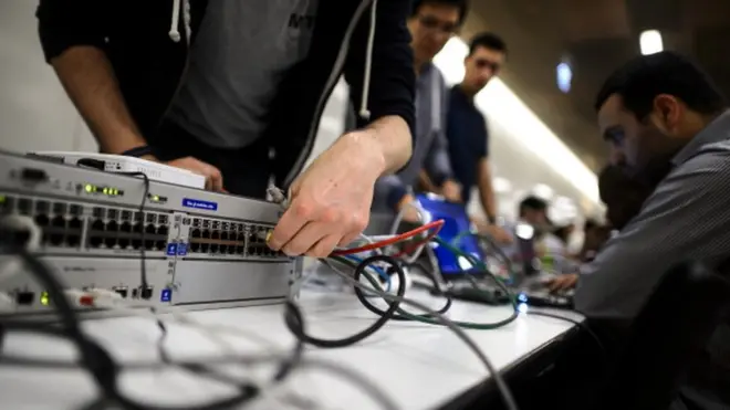 Un participant connecte son ordinateur pour participer à un concours de piratage en 2014, à Genève.