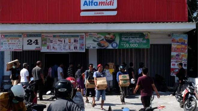 Sejumlah orang mengambil beragam barang dari sebuah minimarket di Palu tanpa membayar, Minggu (30/8).