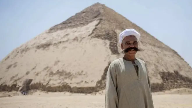 رجل يقف أمام الهرم