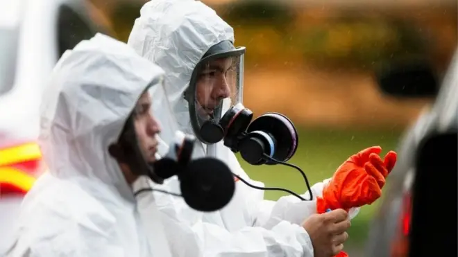 Люди в защитных костюмах