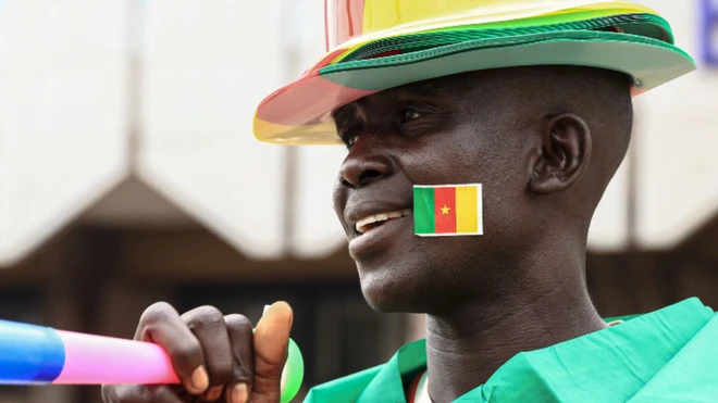 The football tournament kicks off in the West African nation on Sunday - on Wednesday a vendor poses with his wares, which he hopes to sell to home fans.