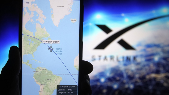 Starlink satellite tracked on a mobile device as it crosses the Atlantic, with Starlink logo in the background