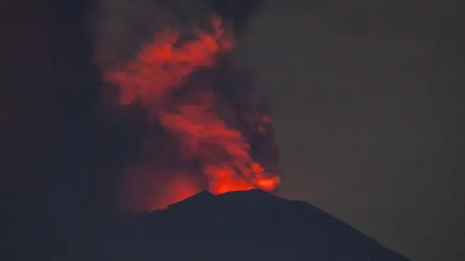 Mount Agung spews volcanic ash into the sky at night on 27 November 2017 in Karangasem, Island of Bali, Indonesia. Indonesian authorities raised the state of alert to its highest level for the volcano, Mount Agung, after thick ash started shooting thousands of meters into the air with increasing intensity