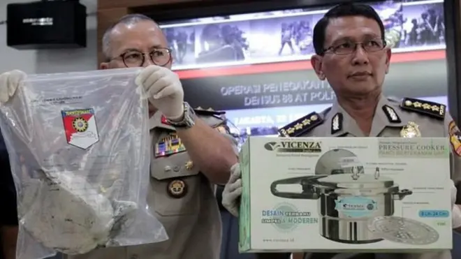 Pejabat kepolisian memegang serpihan bom panci Kampung Melayu, Mei 2017.