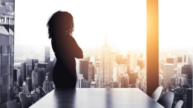 Mulherestrategia roleta corescostas eestrategia roleta coresbraços cruzados aparece dentroestrategia roleta coresescritório olhando para a paisagem externa, com arranha-céus