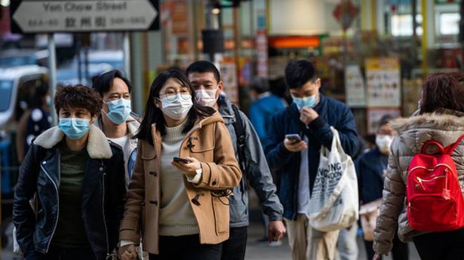 Residents seen wearing surgical masks while crossing the road in Wuhan, the epicentre of the coronovirus outbreak
