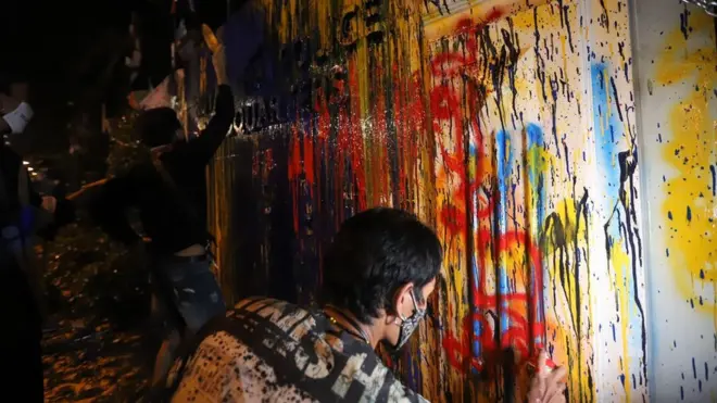 ผู้ชุมนุมกลุ่ม "ราษฎร" สาดสีใส่ป้ายหน้าสำนักงานตำรวจแห่งชาติเมื่อ 18 พ.ย. 2563