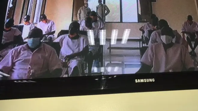 Rusesbagina (imbere ibumoso) n'abo bareganwa bari muri gereza bahuzwa n'urukiko hifashishijwe ikoranabuhanga