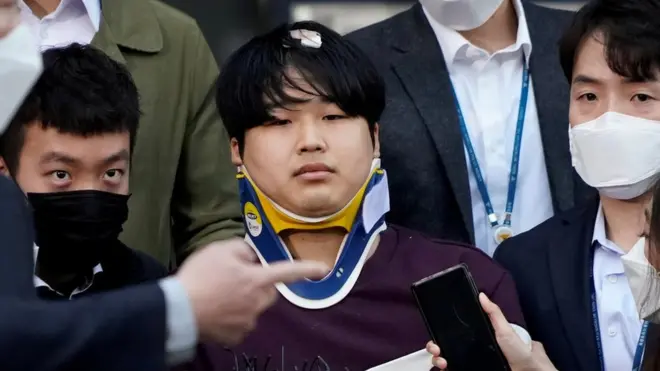 Cho Ju-bin outside the police station, wearing a neck brace