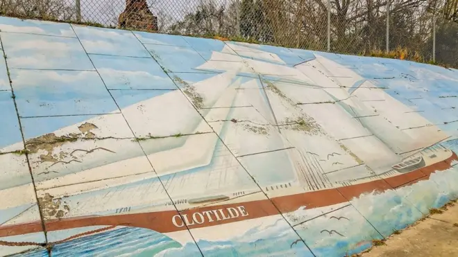 Une peinture murale représentant le navire négrier Clotilda longe l'autoroute qui sépare les deux côtés d'Africatown