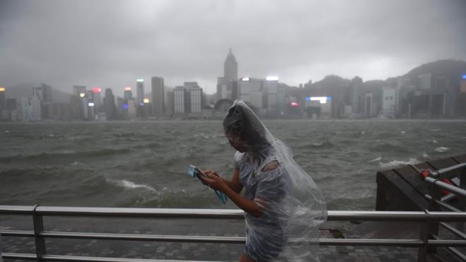 香港尖沙咀海傍一名女士冒着台风观赏维多利亚港（23/8/2017）