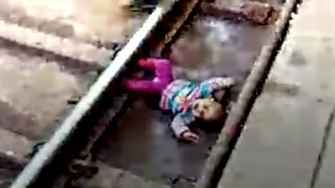 طفلة تنجو من الموت سحقا تحت عجلات القطار في ولاية أوتار براديتش الهندية.