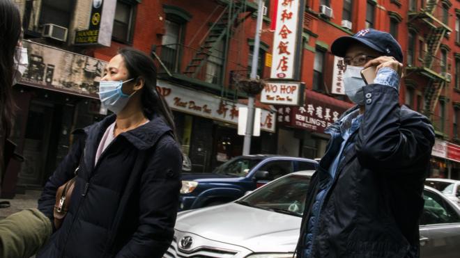 美国纽约唐人街街头戴着口罩走过的华人居民（17/3/2020）