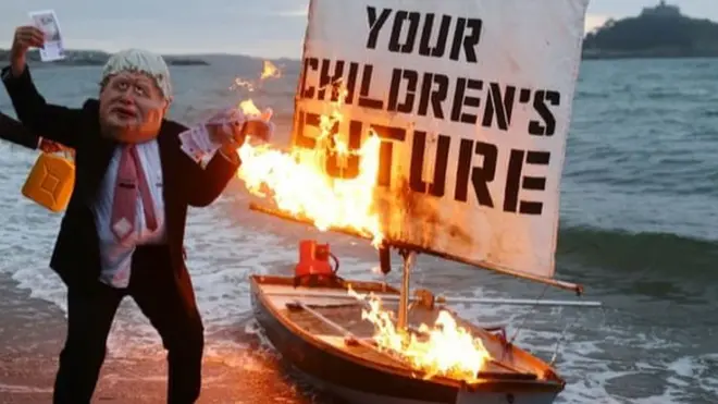 Okyanus İsyani adlı iklim eylem grubu Cornwall'da yapılacak G7 zirvesi öncesinde üzerinde 'Çocuklarınızın geleceği' yazılı bir tekne maketini ateşe verdi