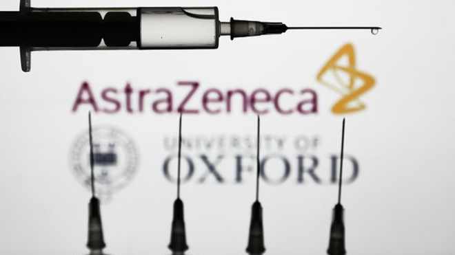 cinco vacinas com logomarca da farmacêutica AstraZeneca e da Universidade de Oxford ao fundo