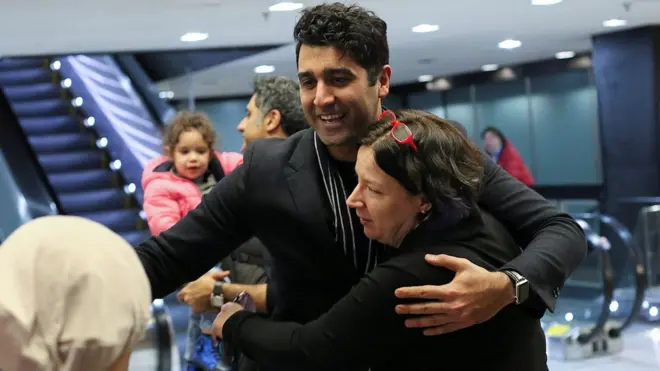 Warga Iran dan pemegang kartu hijau AS, Cyrus Khosravi, memeluk relawan pengacara yang membantunya keluar dari tahanan imigrasi Amerika setibanya di negara itu.