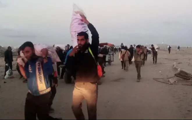 فلسطينيون يحملون إمدادات المساعدات التي تلقوها من مؤسسة غزة الإنسانية المدعومة من الولايات المتحدة في رفح