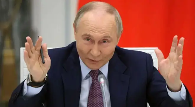 Володимир Путін у костюмі показує руками довжину 