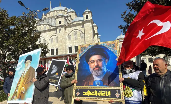 Protesters hold posters of Iran's late Supreme Leader Ayatollah Ali Khamenei and his son, Iran's new Supreme Leader Mojtaba Khamenei, during a protest marking al-Quds Day (Jerusalem Day), amid the U.S.-Israeli conflict with Iran, after a friday prayers at Fatih Mosque in Istanbul, Turkey, March 13, 2026. 
