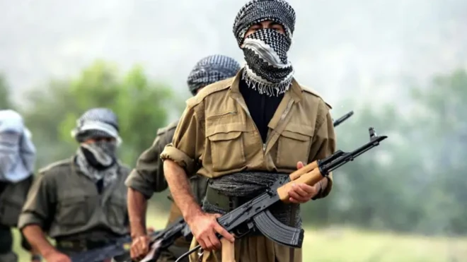 صفی از چریک‌های کرد با اسلحه در دست و صورت‌های پوشیده
