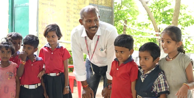 शाळेचे मुख्याध्यापक राजेंद्र परतेकी विद्यार्थ्यांबरोबर