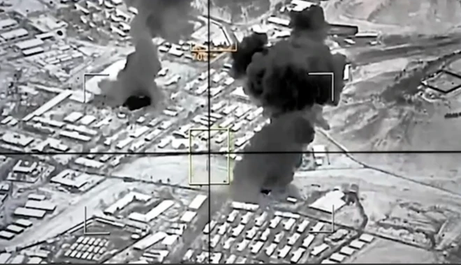 Siyah beyaz fotoğrafta yerleşim yerlerinden duman çıktığı görülüyor