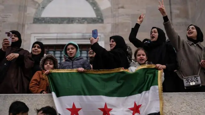 8 Aralık 2024'te, İstanbul Fatih'te, Suriye'deki yönetim değişikliğini kutlayan Suriyeli erkek, kadın ve çocuklar. Ellerinde Suriye muhalefetinin bayrağı var. 