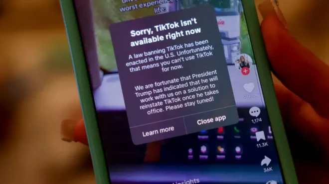 Pesin hold iPhone wit message on dia TikTok app