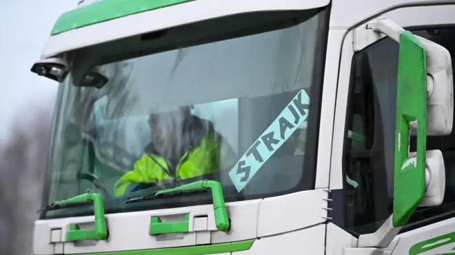 vozač sedi u kamionu na kome piše štrajk