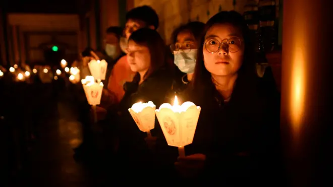 Chinese Catholic faithful hold candles during an Easter mass at a church in Beijing, 30 Mar 2024