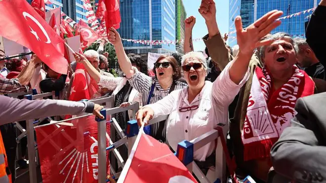 Kırmızı beyaz ağırlıklı bir fotoğrafta en önde iki güneş gözlüklü orta yaşlı kadın var. Çok sayıda Türk bayrağı ve CHP bayrağı da görülüyor. 