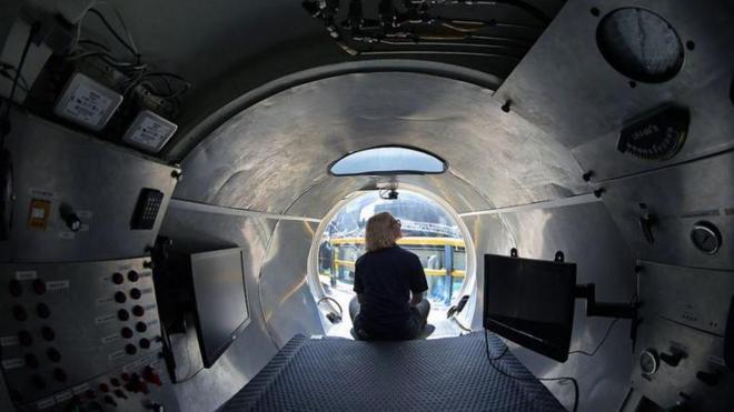 Vista interna do submarino, com mulher sentadaapostas online no são joãocostas na ponta