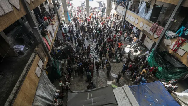 نازحون فلسطينيون يتفقدون مدرسة رفيدة المدمرة في دير البلح وسط قطاع غزة، 10 أكتوبر 2024. ووفقًا لوزارة الصحة الفلسطينية في غزة