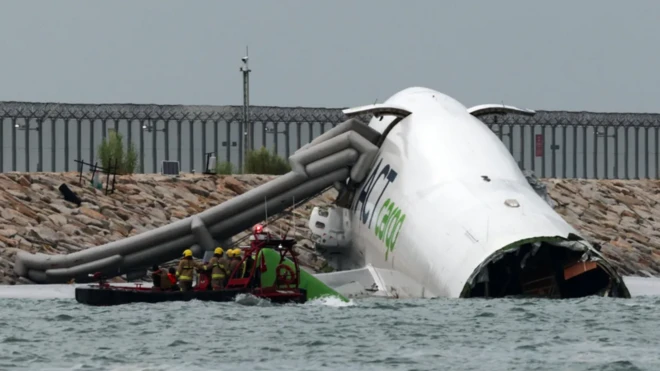 Ọkọ ofurufu akẹru ninu omi okun pẹlu awọn oṣiṣẹ pajawiri to n gbiyanju lati doola ẹmi awọn eeyan.