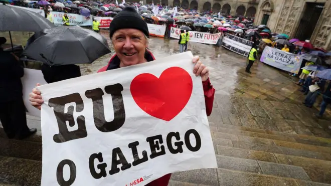 Manifestante segura cartaz com a frase 'Eu amo o galego' durante ato na cidadesite de apostas cblolSantiagosite de apostas cblolCompostela, na Galícia,site de apostas cbloldefesa da promoção e da preservação da língua galega