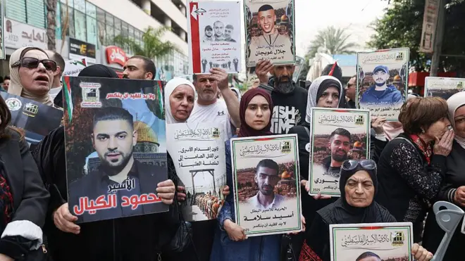 Manifestantes palestinos sostienen fotos de palestinos encarcelados durante una manifestación en Ramala, Cisjordania, para conmemorar el Día de los Presos y protestar contra la aprobación por parte del parlamento israelí de una nueva ley de pena de muerte para palestinos condenados por ataques mortales. 19 de abril de 2026.