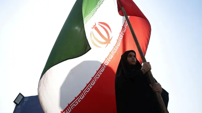 امرأة تحمل العلم الإيراني في أحد شوارع طهران