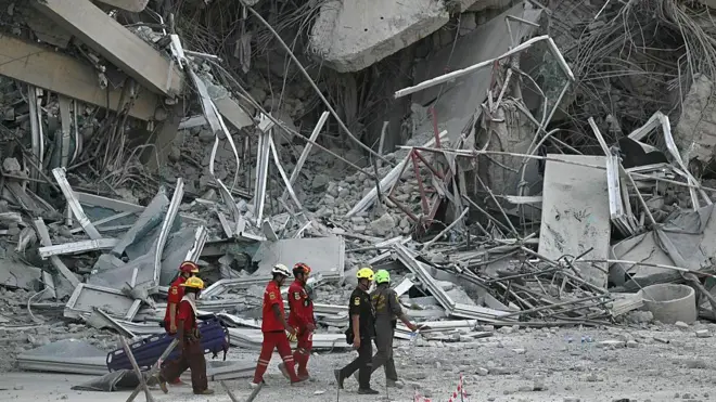 Рятувальники проходять повз уламки будівельного майданчика після того, як будівля обвалилася в Бангкоку 28 березня 2025 року після землетрусу.