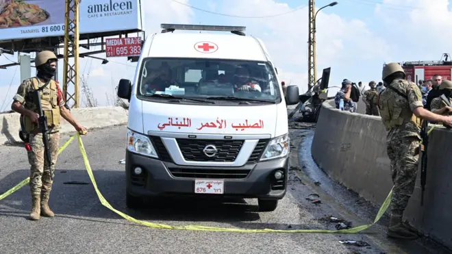 سيارة إسعاف تابعة للصليب الأحمر اللبناني تسير في الموقع الذي استهدفت فيه طائرة مسيرة إسرائيلية سيارة في منطقة عاريا شرقي بيروت، لبنان.