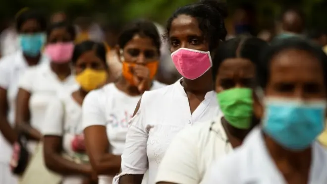 A Sri Lankan women from low income families wearing face masks look on waiting to collect dry rations at Mirisawetiya Buddhist Temple, Anuradhapura, Sri Lanka on July 3, 2020. Sri Lanka have recorded 2069 positive cases of Covid-19 with 1863 recoveries and 11 deaths by the end of 03 July 2020. (Photo by Tharaka Basnayaka/NurPhoto via Getty Images)