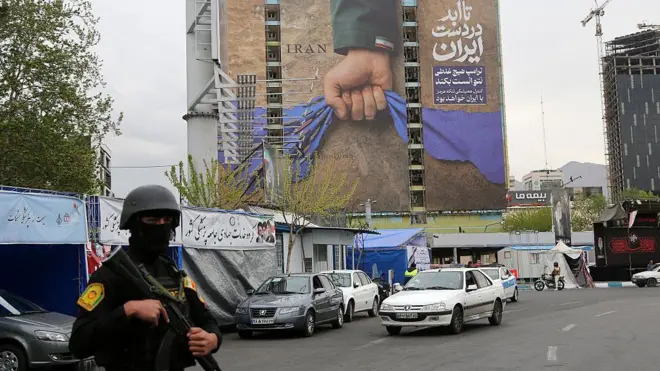 На снимке — большой рекламный щит, установленный на площади Ванак в Тегеране 12 апреля 2026 года. На щите размещены надписи о том, что Ормузский пролив останется под контролем Ирана и что Дональд Трамп не смог добиться результатов