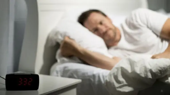 ผู้ชายนอนนบนเตียง