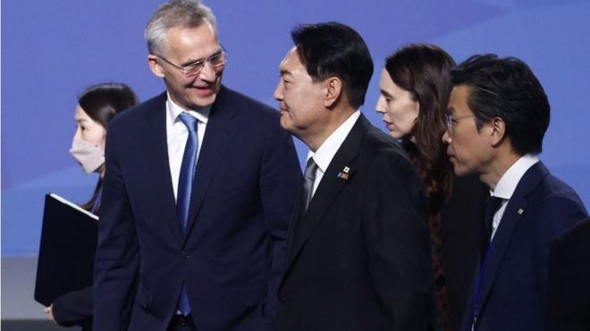 北約峰會首日新聞發佈會後，北約秘書長延斯·斯托爾滕貝格（左）與韓國總統尹錫悅（中）交談。右二為新西蘭總理阿德恩。
