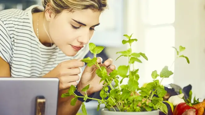 Young woman smelling mint
