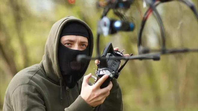 Una persona con una capucha aparentemente volando un dron