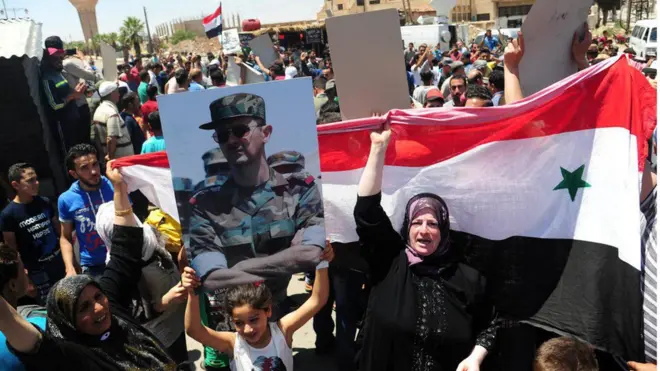 Dera'da Beşar Esad fotoğrafı ve Suriye bayrağı taşıyan kadın ve çocuklar