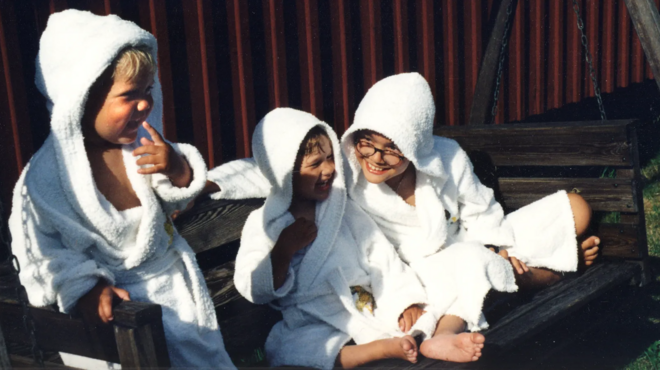 Três crianças rindo no quintal,registro betanoroupão