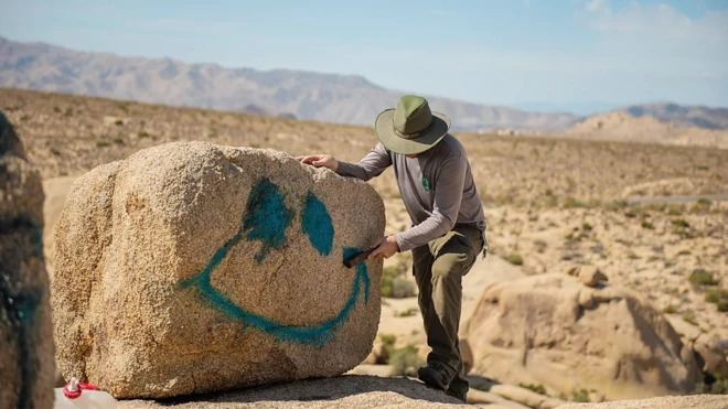 Turista rabisca pedra no deserto