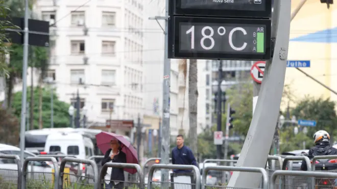 Foto de um termômetro de rua marcando a temperatura de 18 graus. 